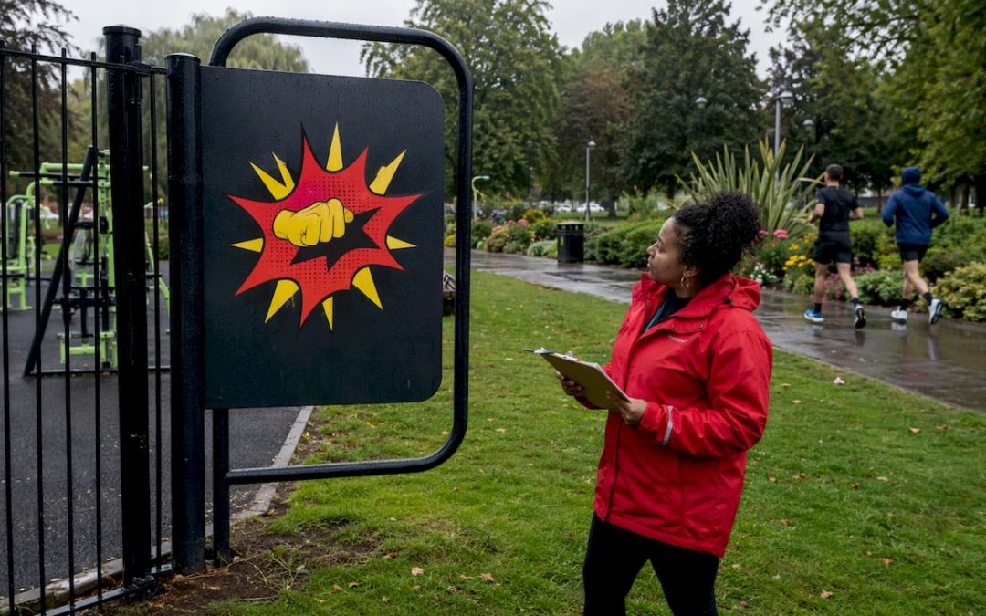 Gym manager inspecting exterior signage outdoors