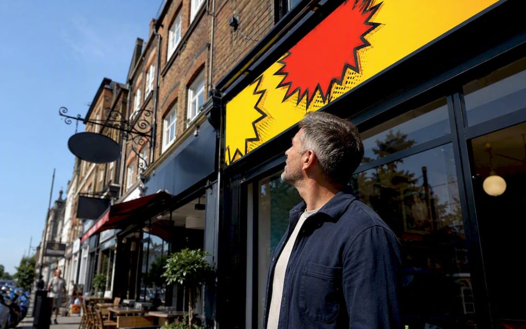 Business owner inspecting outdoor shop sign